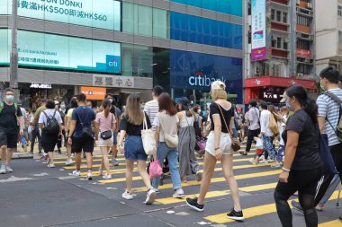 5 Haziran 2021 'de Mong Kok' ta karşıdan karşıya geçerken koruyucu maskeler takıyorlar.