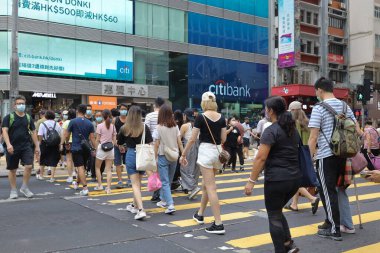 5 Haziran 2021 'de Mong Kok' ta karşıdan karşıya geçerken koruyucu maskeler takıyorlar.