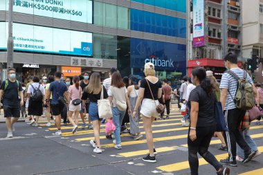 5 Haziran 2021 'de Mong Kok' ta karşıdan karşıya geçerken koruyucu maskeler takıyorlar.