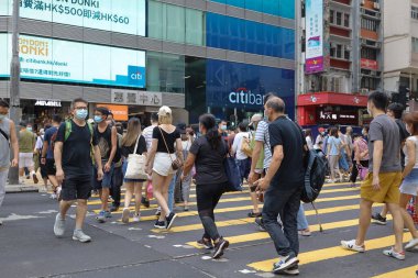 5 Haziran 2021 'de Mong Kok' ta karşıdan karşıya geçerken koruyucu maskeler takıyorlar.
