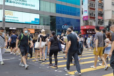 5 Haziran 2021 'de Mong Kok' ta karşıdan karşıya geçerken koruyucu maskeler takıyorlar.