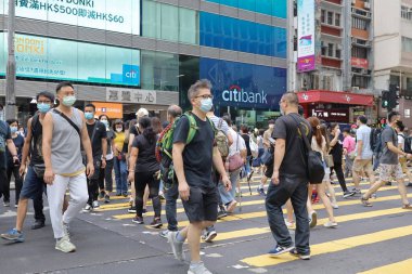 5 Haziran 2021 'de Mong Kok' ta karşıdan karşıya geçerken koruyucu maskeler takıyorlar.