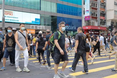 5 Haziran 2021 'de Mong Kok' ta karşıdan karşıya geçerken koruyucu maskeler takıyorlar.