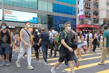 5 Haziran 2021 'de Mong Kok' ta karşıdan karşıya geçerken koruyucu maskeler takıyorlar.