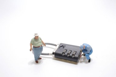 Küçük bir adam şifre kilidini kırmaya çalışıyor..