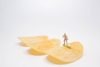 Sörfçü Mini, patates cipsi üzerinde sörf yapıyor.