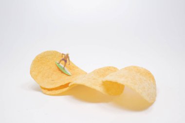 Sörfçü Mini, patates cipsi üzerinde sörf yapıyor.