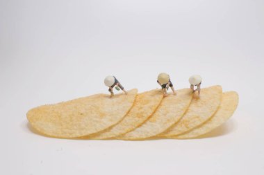 Minyatür Asyalı çiftçiler patates cipsi hazırlıyorlar.