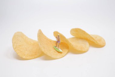 Sörfçü Mini, patates cipsi üzerinde sörf yapıyor.