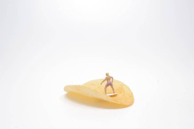 Sörfçü Mini, patates cipsi üzerinde sörf yapıyor.