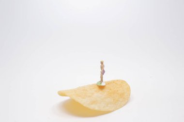 Sörfçü Mini, patates cipsi üzerinde sörf yapıyor.