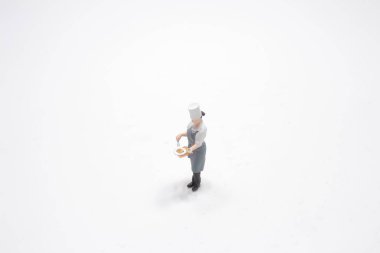 Beyaz tenli bir kadın şef figürü.