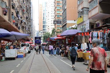 2 Temmuz 2021 'de alışveriş yapanlar Hong Kong' da tramvay raylarının geçtiği sokak nemli pazarında.