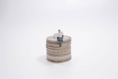 İş adamı mini figürü oturuyor ve gazete okuyor.