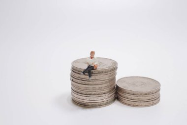 İş adamı mini figürü oturuyor ve gazete okuyor.