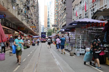2 Temmuz 2021 'de alışveriş yapanlar Hong Kong' da tramvay raylarının geçtiği sokak nemli pazarında.