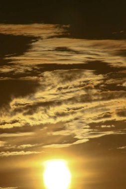 Bulutların üzerinde dramatik bir ışıkla gün batımı..