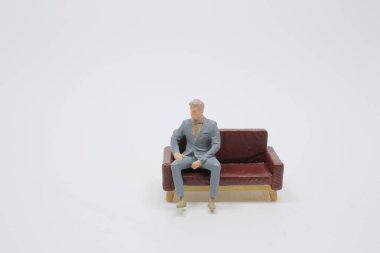 Komik figür minnacık kanepeye otur.