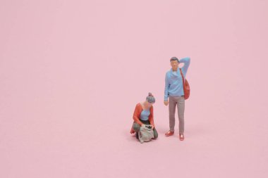 Minyatür heykel çantasında bir şey arıyor.