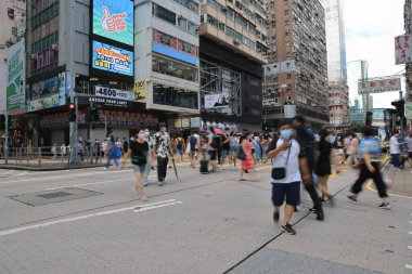 15 Ağustos 2021 Mong Kok 'taki işlek cadde, insanlar Trhe Yolu' nu geçiyor.