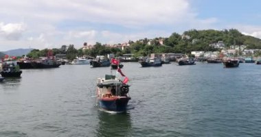 Cheung Chau, Hong Kong, 20 Ağustos 2021 'de kalabalık bir balıkçı limanında hareket eden tekne. 