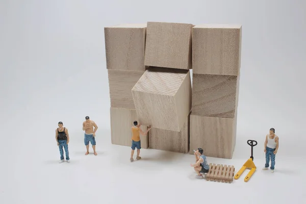 小さな労働者が大きな木の立方体を動かし — ストック写真