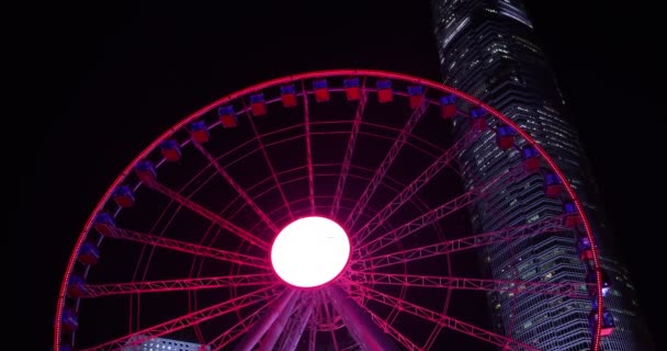 Κίνηση Hong Kong Observation Wheel Και Ουρανοξύστης Φόντο Που Φωτίζεται — Αρχείο Βίντεο
