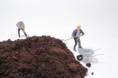 Küçük işçi figürleri öğütülmüş kahve üzerinde çalışıyor