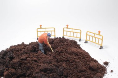 Küçük işçi figürü öğütülmüş kahve üzerinde çalışıyor.