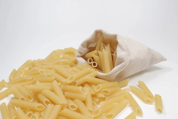 Penne Pasta Verschüttet Aus Tüte Auf Weißem Hintergrund — Stockfoto