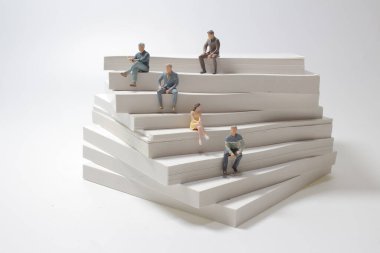 İş adamı figürü kağıt yığınının üzerine oturur. İş kavramındaki büyüme.