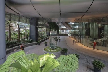 Kavisli cam duvarları ve pürüzsüz bir yürüyüş yolu olan gösterişli şirket avlusu.,