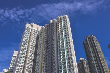 A cluster of high-rise residential towers rises into a bright blue sky