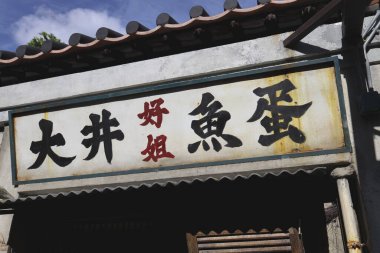 Eski bir Çin mağazasının vitrininde kalın tabelalar var.