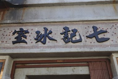 Eski bir Çin mağazasının vitrininde kalın tabelalar var.