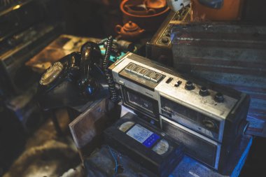 Retro stereo teyp bir çevirmeli telefon ve klasik bir kasetin yanında duruyor.,