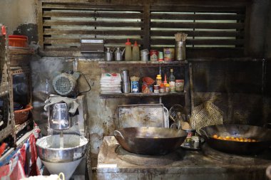 Kırsal, endüstriyel bir mutfak, yıpranmış bir sobada iki büyük tava.,