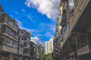 Eski apartman blokları ve balkonlarla dolu hareketli bir sokak.,