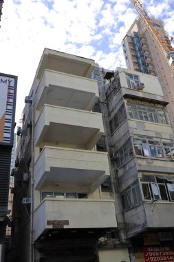 narrow city street shows older apartment blocks with balconies