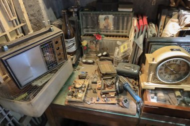 A crowded, aged shop filled with metalworking machines, a blue press
