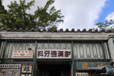 Çerçevesinde güvercinler olan yıpranmış bir Çin kapısı.,