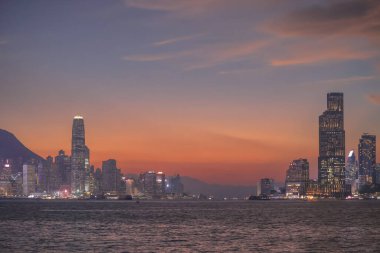 Sakin günbatımı şehir ufkunu çiziyor siluetli gökdelenler liman boyunca dikilirken