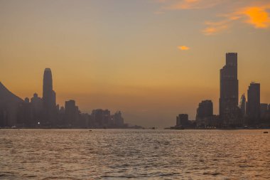 Sakin günbatımı şehir ufkunu çiziyor siluetli gökdelenler liman boyunca dikilirken