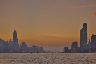 Sakin günbatımı şehir ufkunu çiziyor siluetli gökdelenler liman boyunca dikilirken