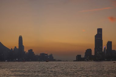 Sakin günbatımı şehir ufkunu çiziyor siluetli gökdelenler liman boyunca dikilirken