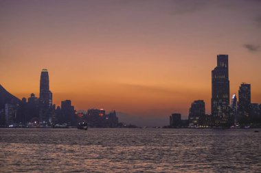 Sakin günbatımı şehir ufkunu çiziyor siluetli gökdelenler liman boyunca dikilirken