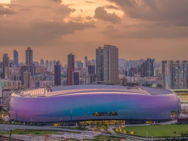 Modern stadyum Alacakaranlık Kowloon siluetinin altında aydınlandı
