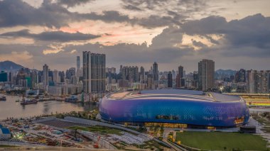 Modern stadyum Alacakaranlık Kowloon siluetinin altında aydınlandı