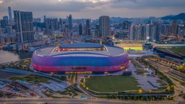 Modern stadyum Alacakaranlık Kowloon siluetinin altında aydınlandı