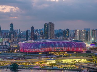 Modern stadyum Alacakaranlık Kowloon siluetinin altında aydınlandı